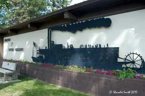 A wall mural of a steamboat on the exterior of a building.