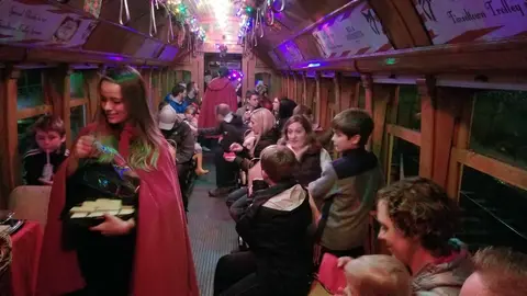 Passengers inside a festively decorated vintage railcar.