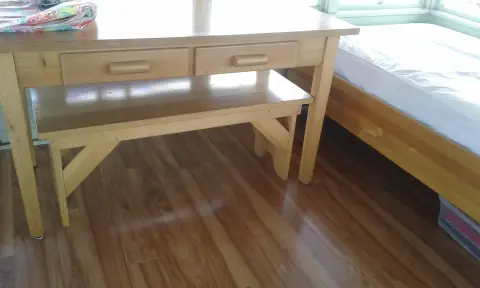 A wooden table and bench are set up inside a room.