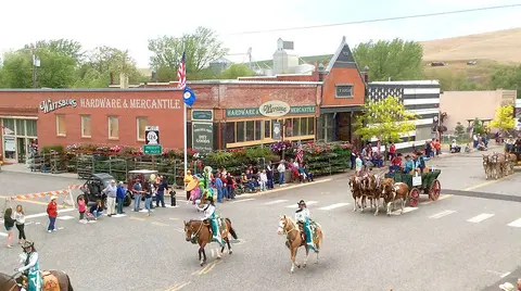 An elevated view of a parade moving through a small town street.