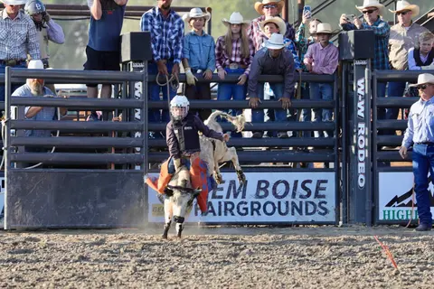 A young bull rider competes at a rodeo event.