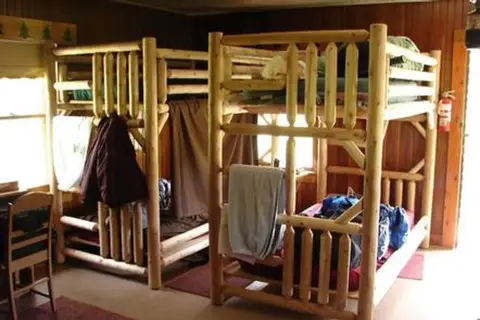 An interior shot shows wooden bunk beds in a room.