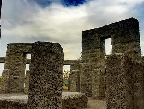 A stone monument stands under a cloudy sky.