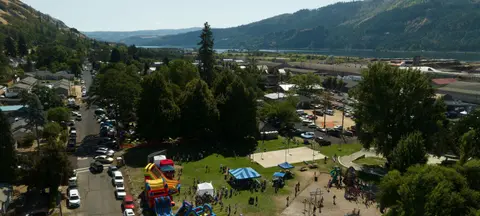 An elevated view of a park and town with mountains in the background.