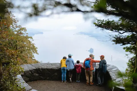 A group of people look out over a wide body of water from an overlook.