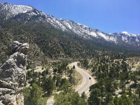 A winding road through a mountainous landscape with snow-capped peaks.