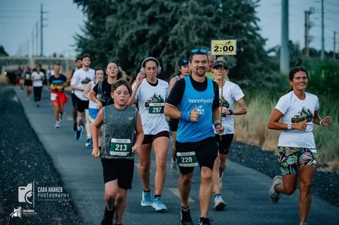 A group of people running on a paved path during a race.
