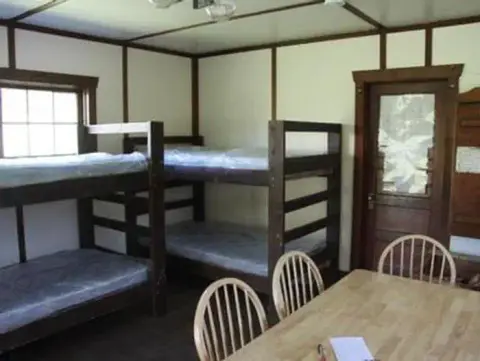Interior view of a room with bunk beds and a table.