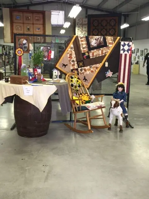 Quilts and crafts are displayed inside a large hall.
