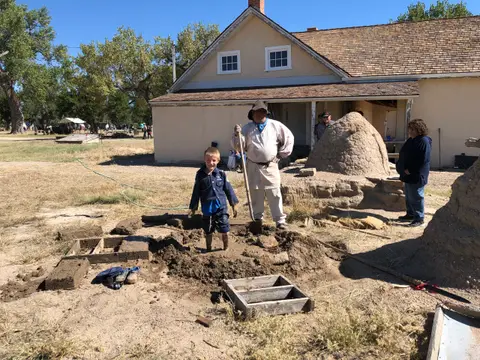 People participating in a muddy activity outside a historic building.