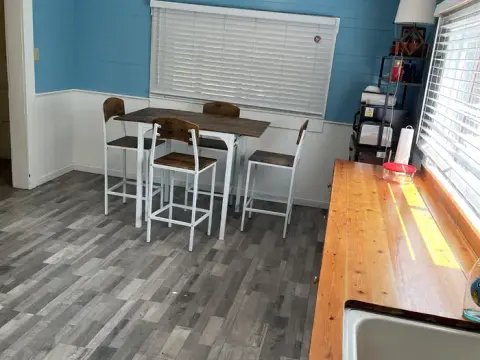 An interior view of a room with a dining table and wooden counter.