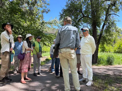 A group of people standing together outdoors along a path.