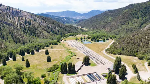 An aerial view of a fish hatchery nestled in a mountain valley.