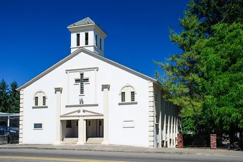 Exterior view of a white church building under a clear blue sky.