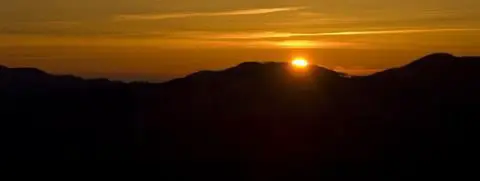A sunset over mountain silhouettes.