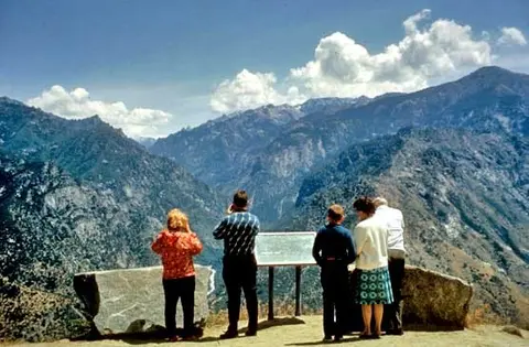 People looking out over a mountain canyon from an overlook.