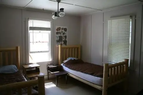 An interior bedroom with two twin log frame beds.