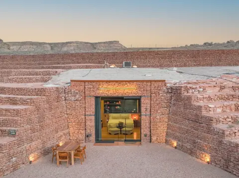 An earth-sheltered suite built into a terraced red rock landscape.
