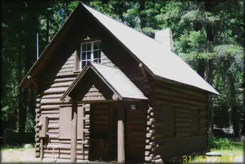 A rustic wooden cabin nestled among trees.