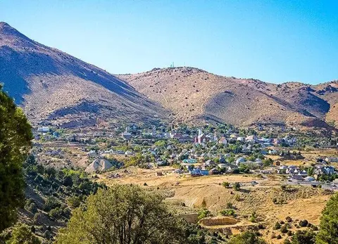 A town nestled in a valley surrounded by arid mountains.