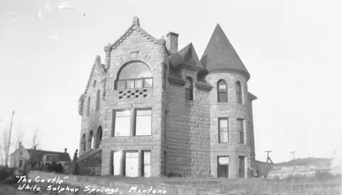 Historic black and white photo of a stone castle-style building.