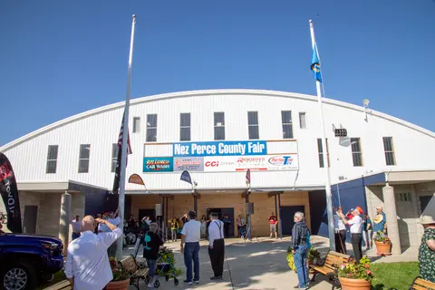 A group of people standing outside a large fair building.