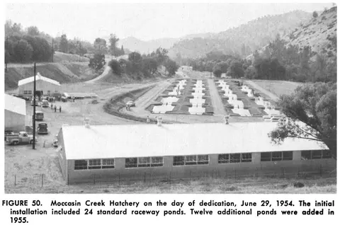 An old black and white photo of an outdoor facility with buildings and ponds in a valley.