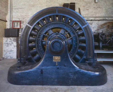 A large industrial generator sits inside a building.