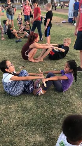 Children participate in outdoor games on the grass.