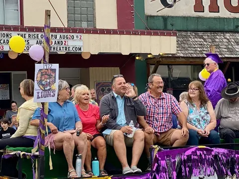A group of people riding on a decorated parade float.