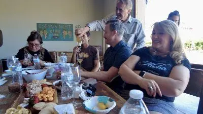 People gathered around a table enjoying food and wine indoors.