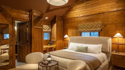 A bedroom with wooden walls and a large bed.