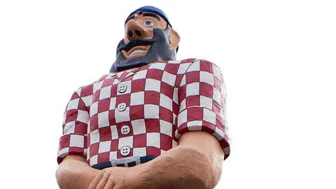 A low-angle photograph of a large statue wearing a red and white checkered shirt.