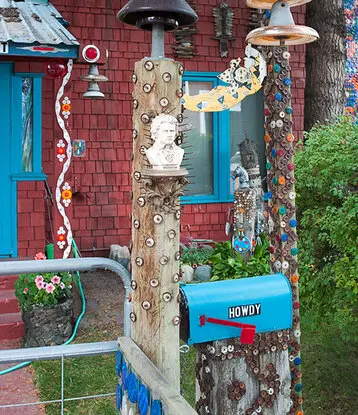 A brightly decorated house exterior features whimsical posts and a blue mailbox.