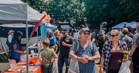 A photograph shows a crowd of people at an outdoor event or fair.