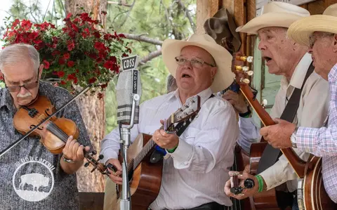 A band of men playing music and singing outdoors.