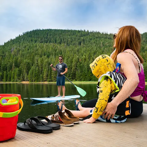 A family enjoys a sunny day by a scenic mountain lake.