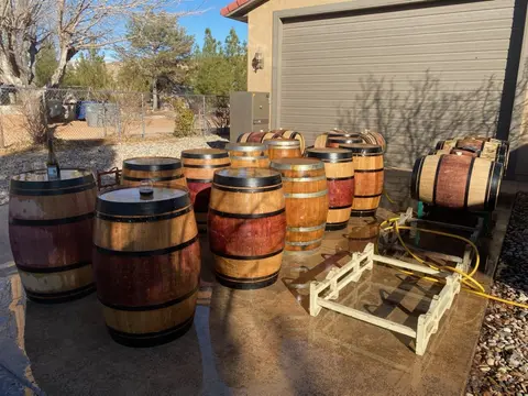 A collection of wooden barrels outside a garage.
