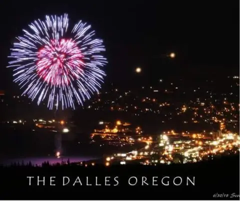 Fireworks light up the night sky over a city.