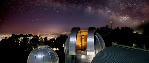 An observatory dome stands under a starry night sky.