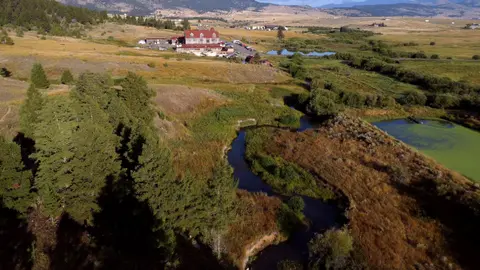 An aerial photograph of a winding river and a large building in a valley.