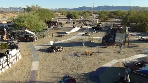 An outdoor art installation in the desert with sculptures and structures.