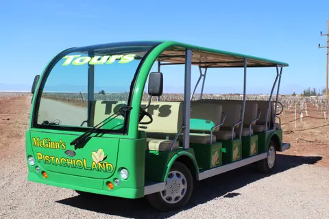 A green open-air tour vehicle parked outdoors.