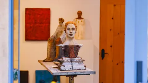 Ceramic sculptures displayed on a table inside a room.