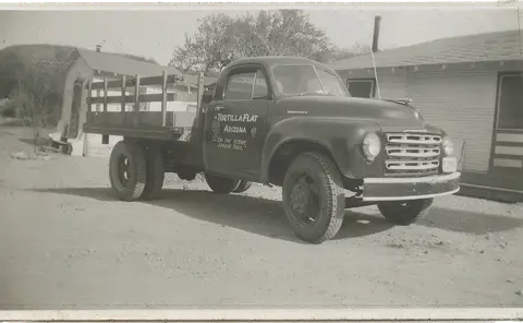 A vintage truck parked outside buildings.