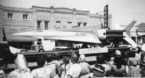 A crowd of people view a U.S. Army missile on display.