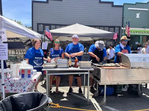 People working at an outdoor food stand.