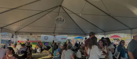 People gather under a large event tent.