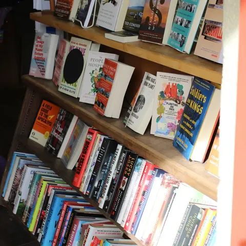 A wooden bookshelf is filled with various books.
