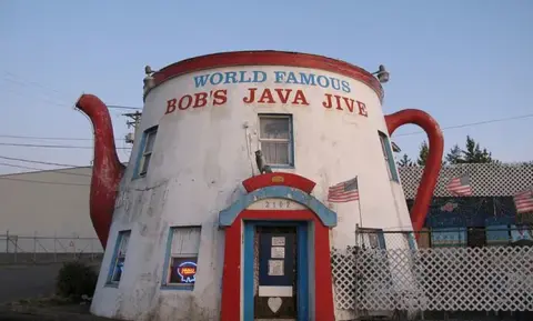 An exterior view of a unique building shaped like a giant teapot.